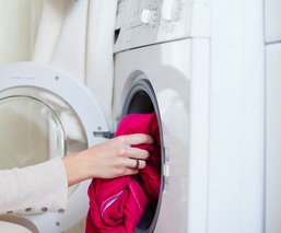 Housework: young woman doing laundry (shallow DOF; color toned image)